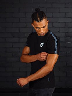 Model draagt zwart DIRE Wovenband T-Shirt met op de linker borst wit DIRE logo